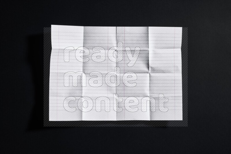 Folded notebook sheet on black background