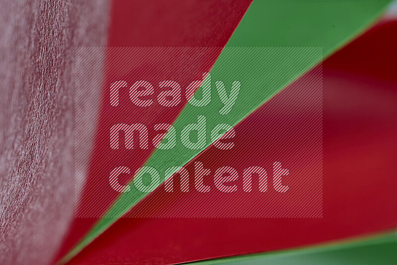 An abstract art showing red and green paper sheets arranged in an overlapping curves