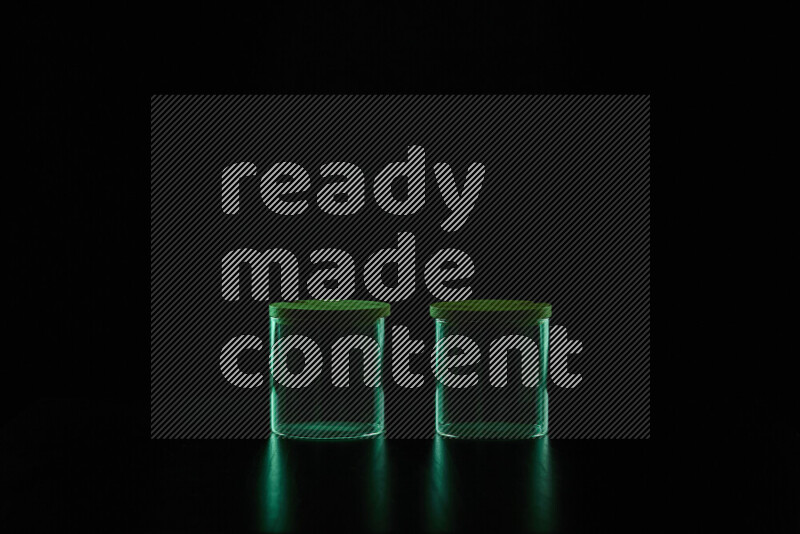 Glassware with rim light in green against black background