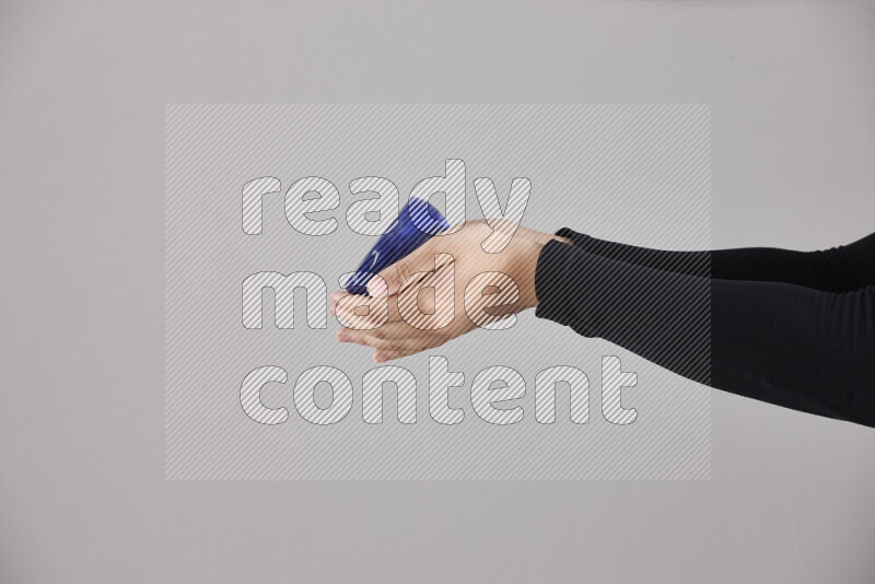 A woman in black abaya holding different pottery essentials in different positions