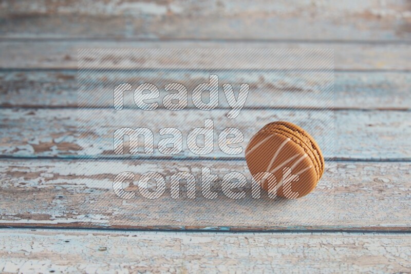 45º Shot of Brown Irish Cream macaron on light blue wooden background