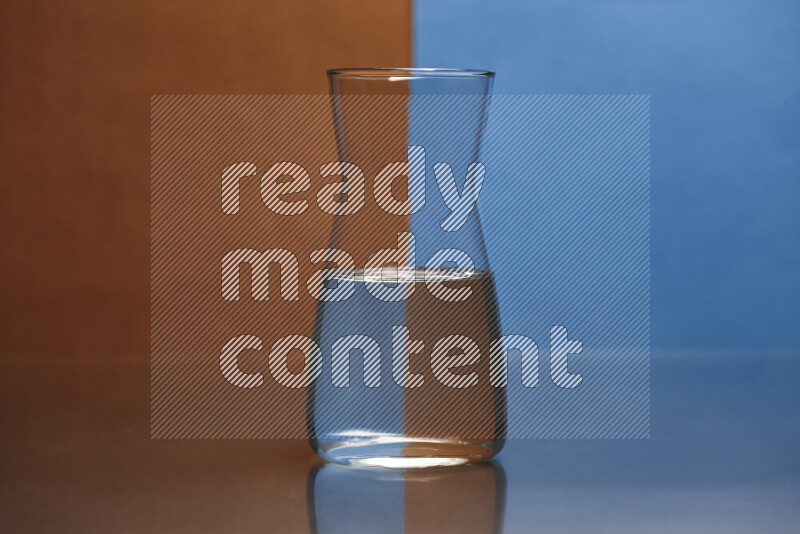 The image features a clear glassware filled with water, set against brown and blue background