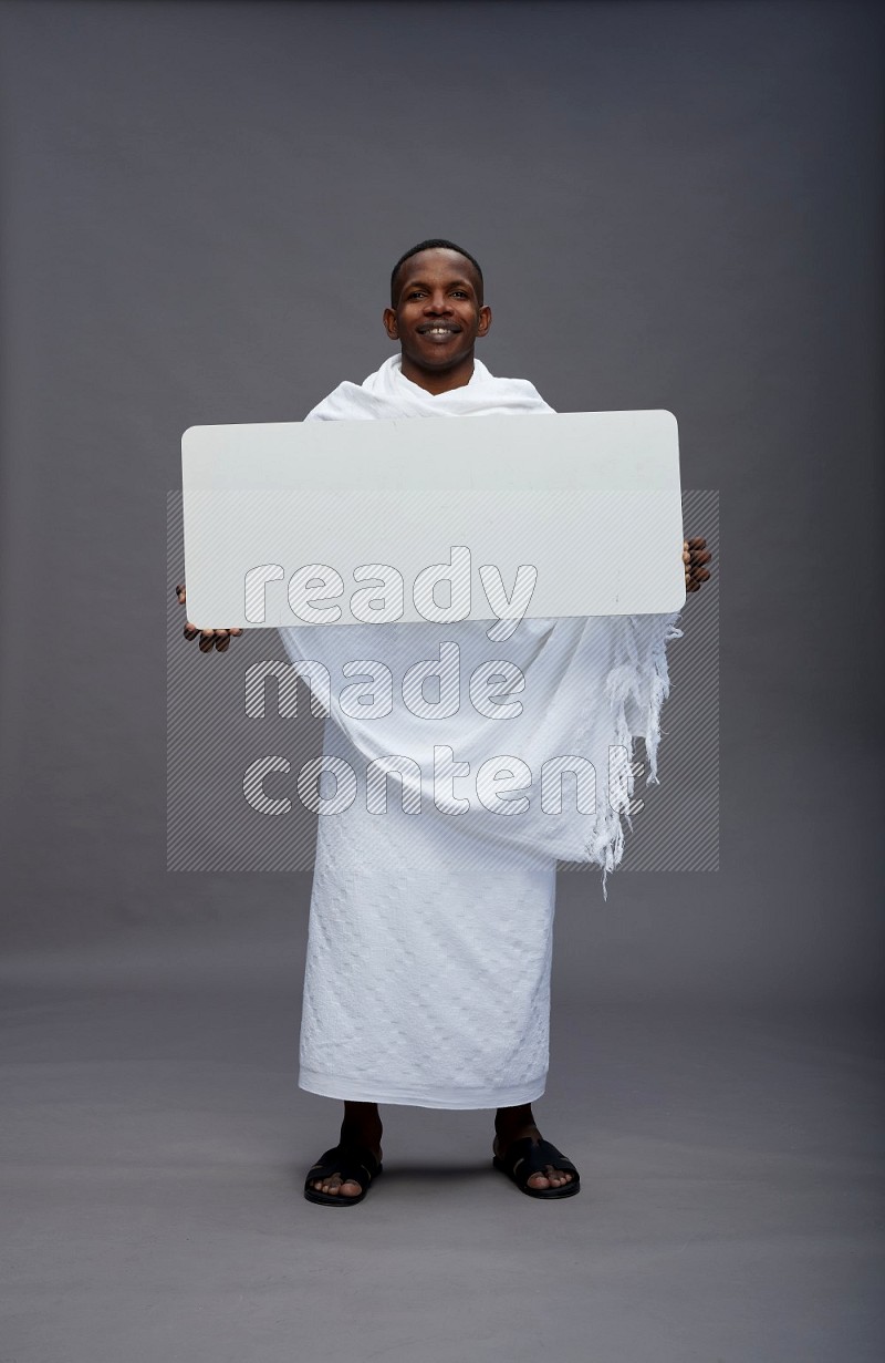 A man wearing Ehram Standing holding board sign on gray background