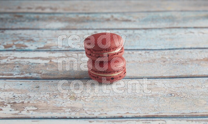 45º Shot of two Red Velvet macarons on light blue wooden background