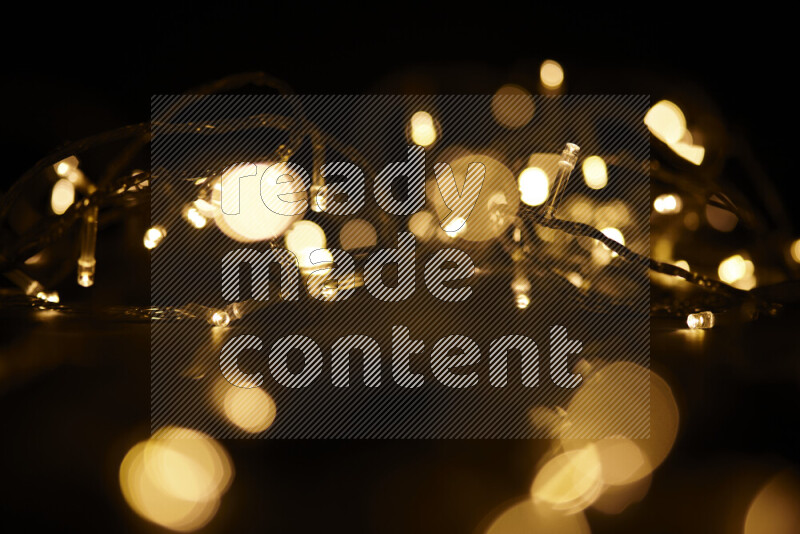 Light bulbs glowing against backdrop of golden bokeh