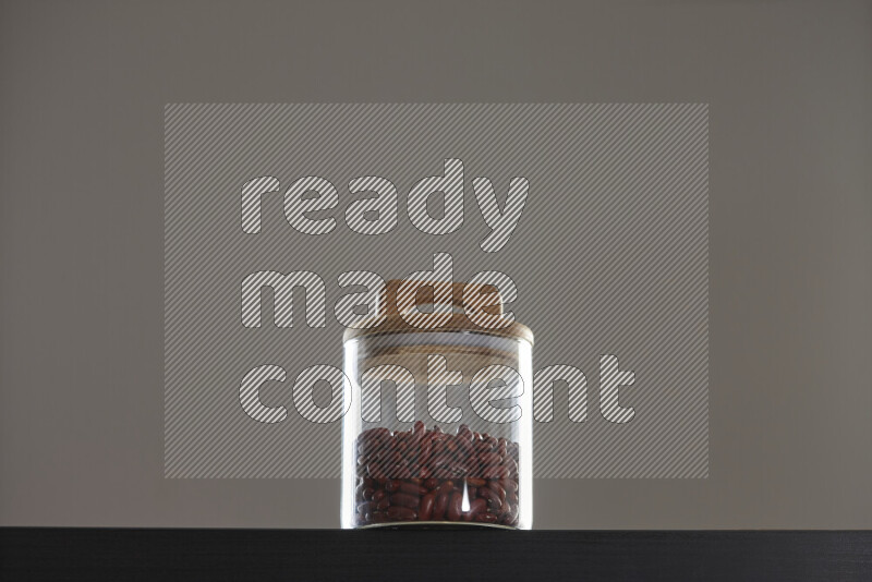 Red kidney beans in a glass jar on black background