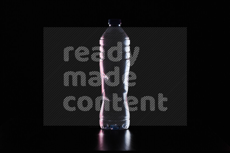 Water bottle with colored rim light against black background