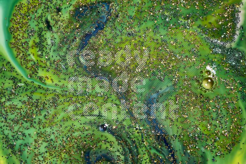 A close-up of sparkling gold glitter scattered on swirling blue and green background