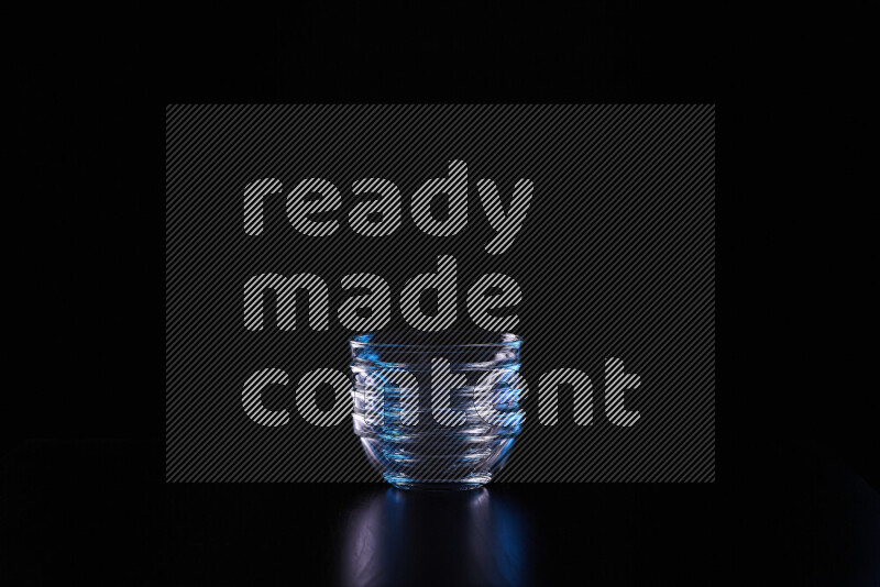 Glassware with rim light in blue and white against black background