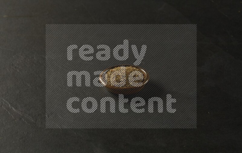 multi color round sauce bowl filled with herbs on grey textured countertop