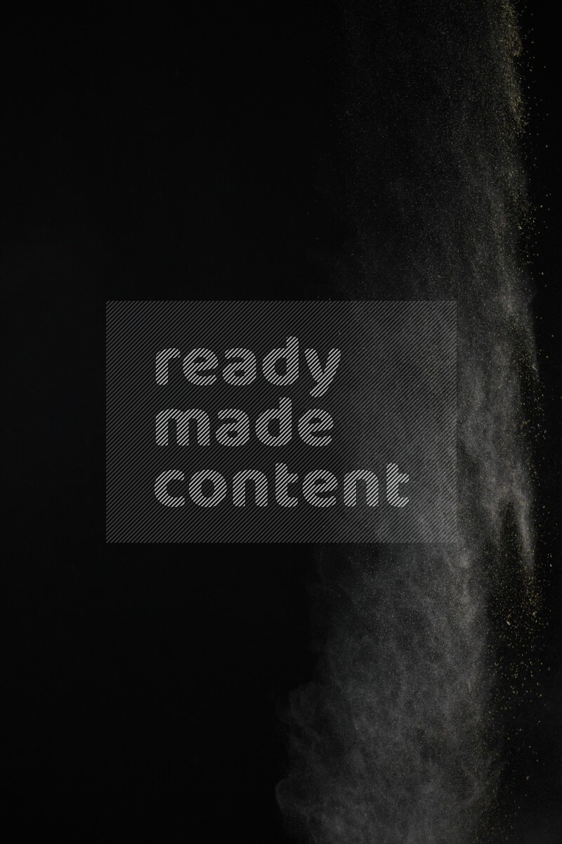 A side view of brown powder explosion on black background