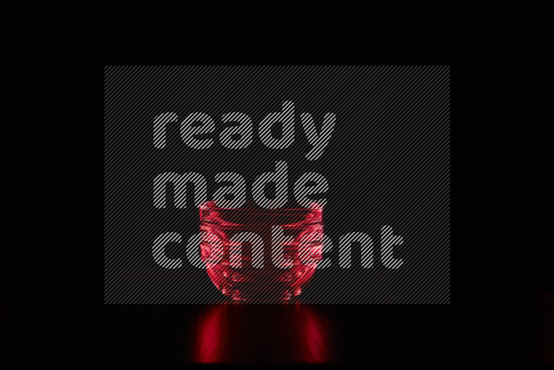 Glassware with rim light in red against black background