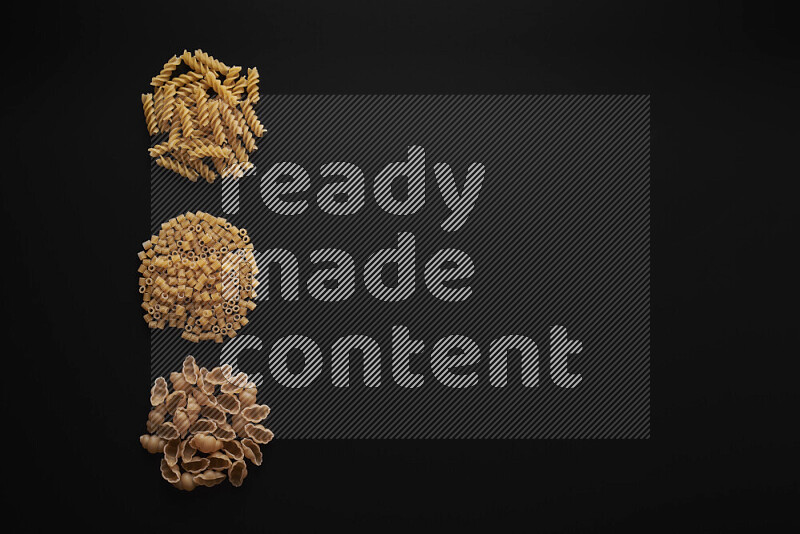 Different pasta types in 3 bunches on black background