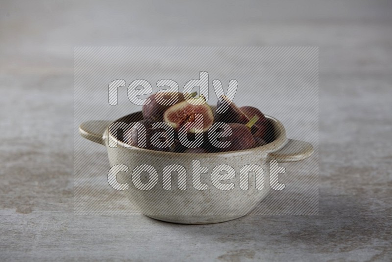 Fresh figs in a bowl on textured grey background