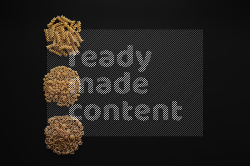 Different pasta types in 3 bunches on black background