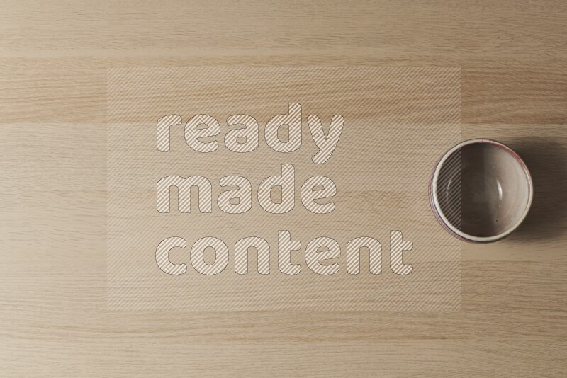 وعاء فخاري متعدد الألوان على خلفية خشبية فاتحة