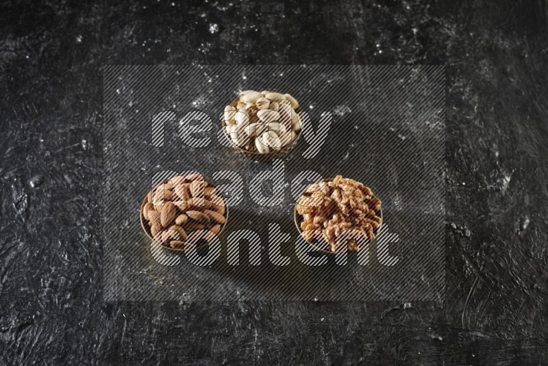 مكسرات في وعاء معدني علي خلفية سوداء