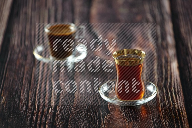 A tea glass cup with dates and coffee on wooden background