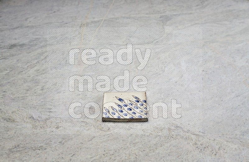 Top view shot of a pottery coaster\ tile on beige marble flooring