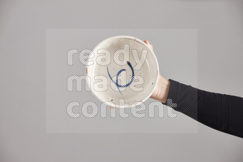 A woman in black abaya holding different pottery essentials in different positions