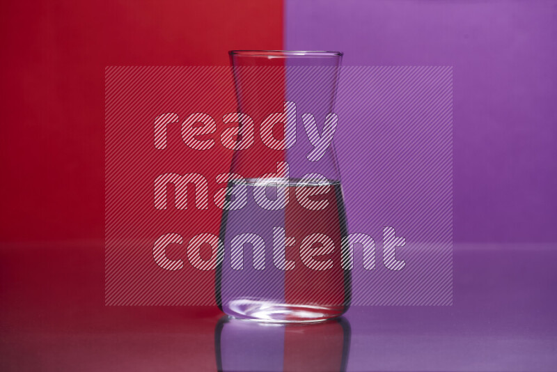 The image features a clear glassware filled with water, set against red and purple background