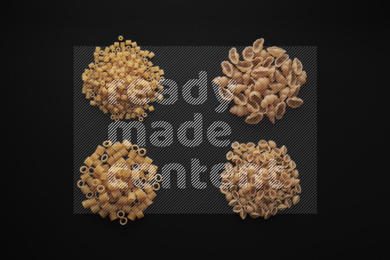 Different pasta types in bunches on black background