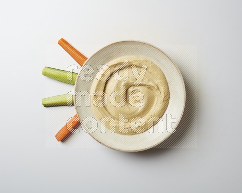 plain Hummus in a pottry plate  on a white background
