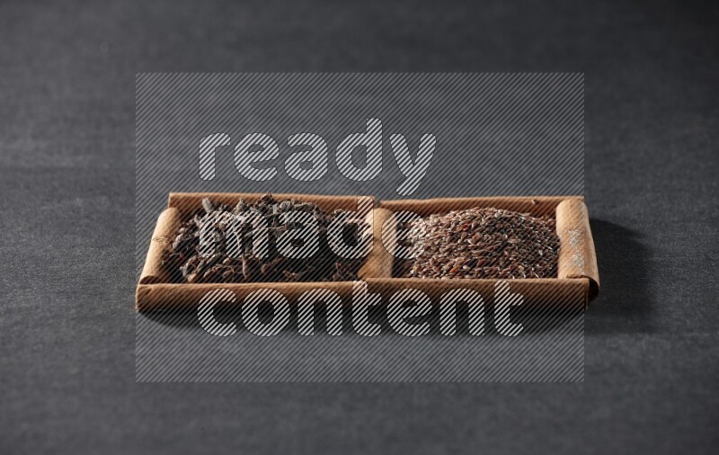 2 squares of cinnamon sticks full of flaxseeds and cloves on black flooring