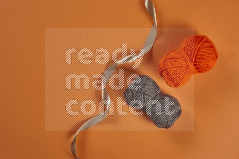 A brown collection of sewing and tailoring tools arranged on a orange background