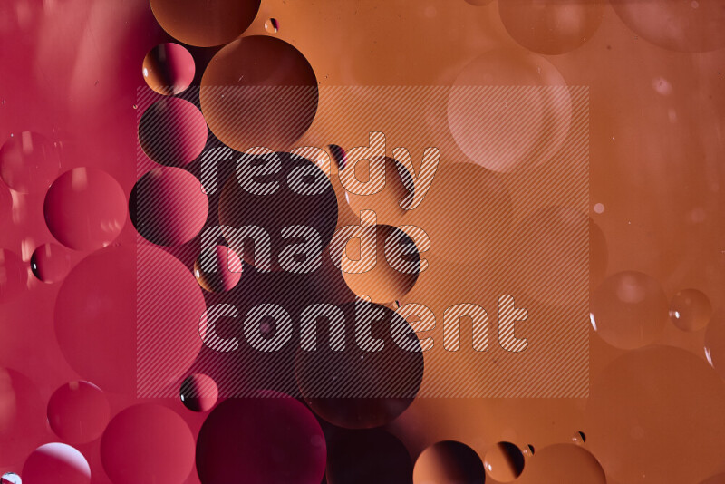 Close-ups of abstract oil bubbles on water surface in shades of red and orange