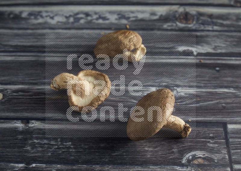 45 degree shiitake  mushrooms on a textured grey wooden background