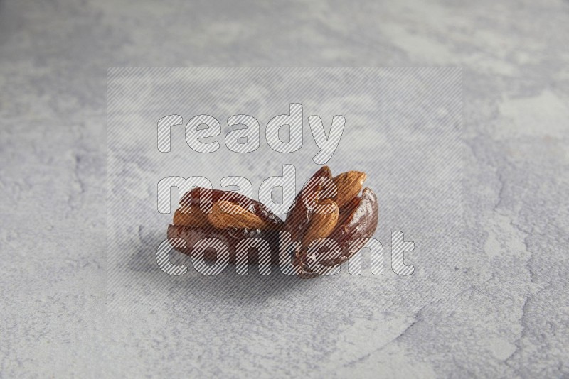 Two Almond stuffed date on a light grey background