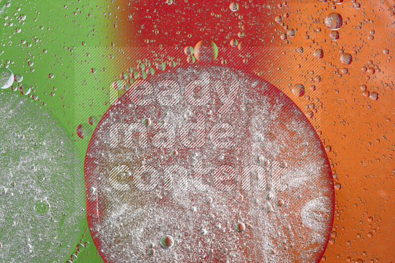 Close-ups of abstract oil bubbles on water surface in shades of orange, green and red