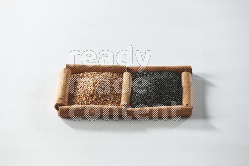 2 squares of cinnamon sticks full of mustard seeds and black seeds on white flooring