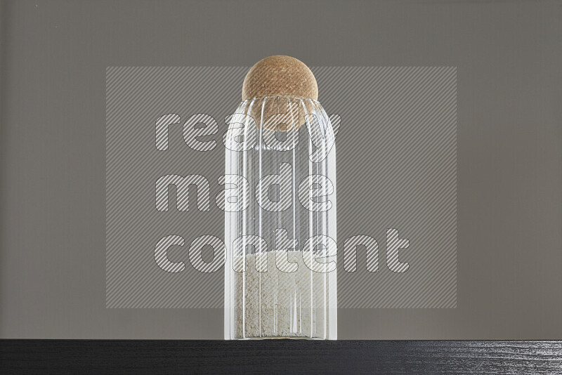 Desiccated coconut in a glass jar on black background