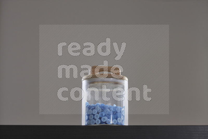 Buttons in a glass jar on black background