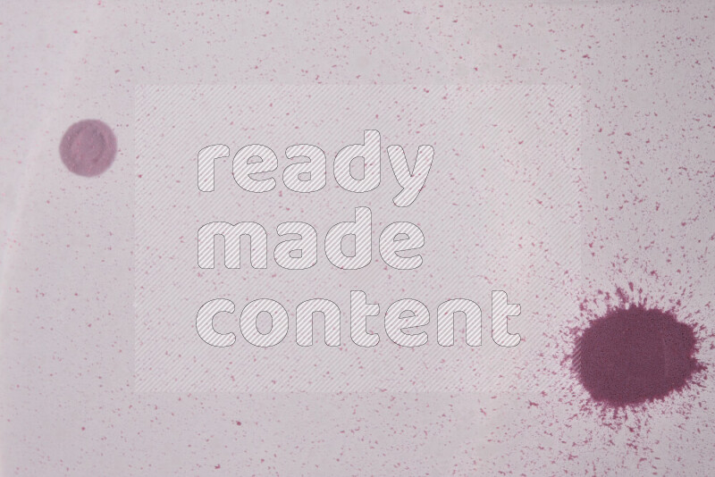 The image captures a dramatic splatter of purple paint over a white backdrop