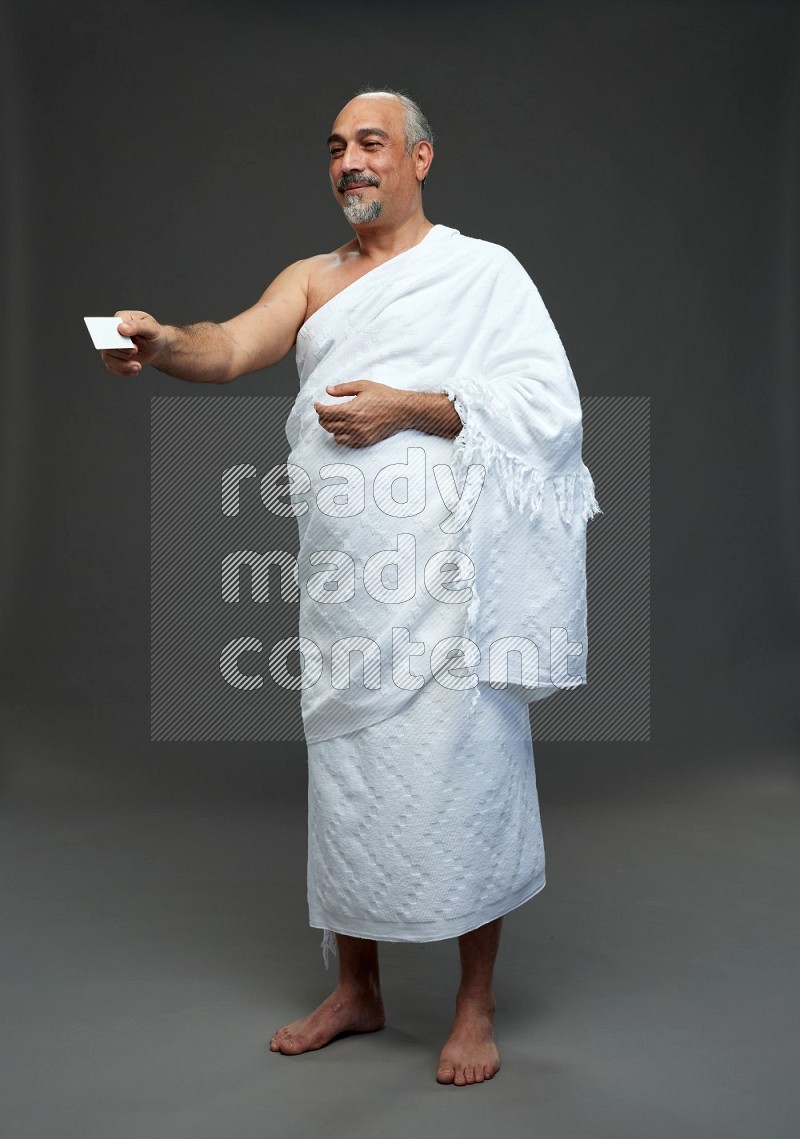 A man wearing Ehram Standing holding ATM card on gray background