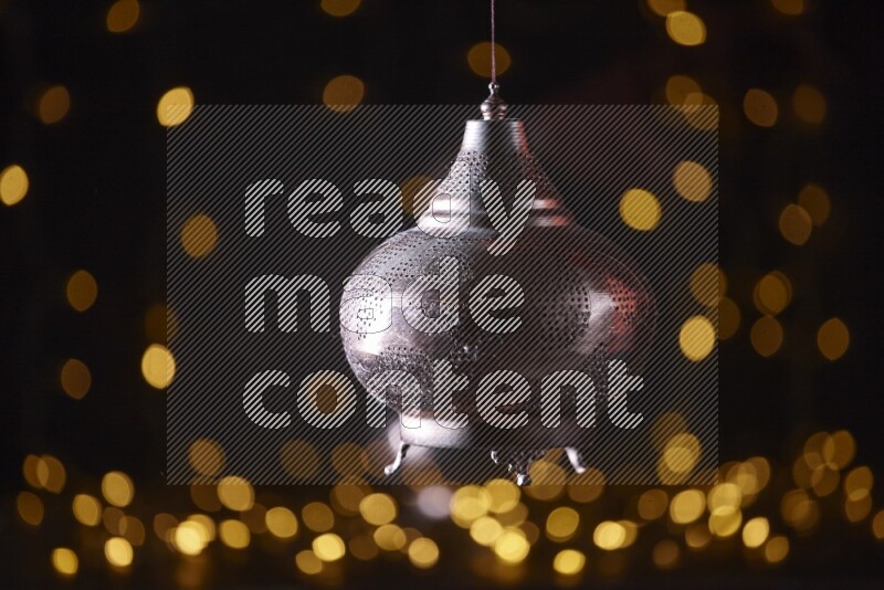 A traditional ramadan lantern surrounded by glowing fairy lights in a dark setup