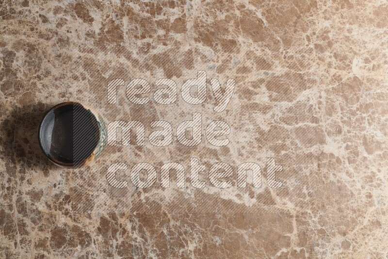 وعاء فخاري متعدد الألوان على خلفية من الرخام البيج