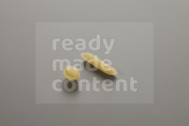 معكرونة ودعة في وعاء فخاري علي خلفية رمادية