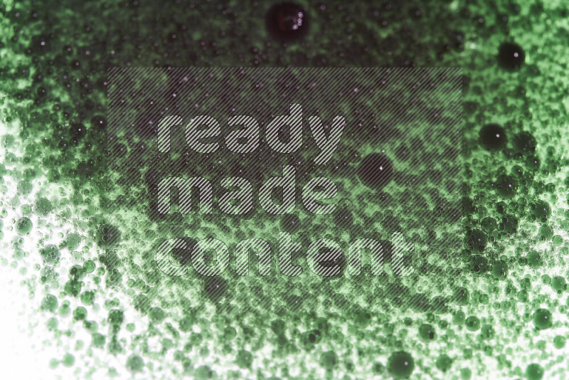 لقطات مقربة لقطرات ألوان مائية خضراء على سطح الزيت على خلفية بيضاء