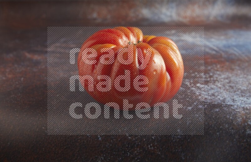 45 degree single heirloom tomato on  a textured reddish rustic metal background