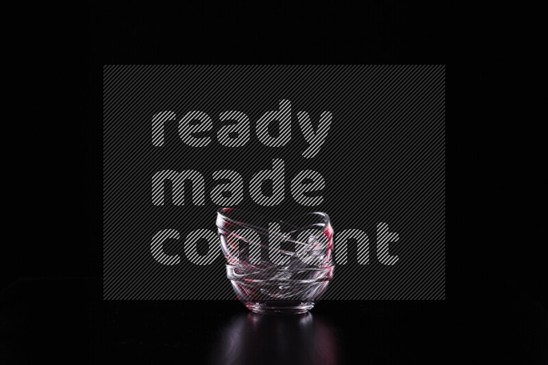 Glassware with rim light in red and white against black background