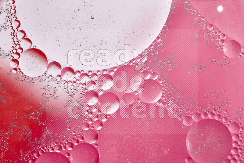 Close-ups of abstract oil bubbles on water surface in shades of white, red and pink