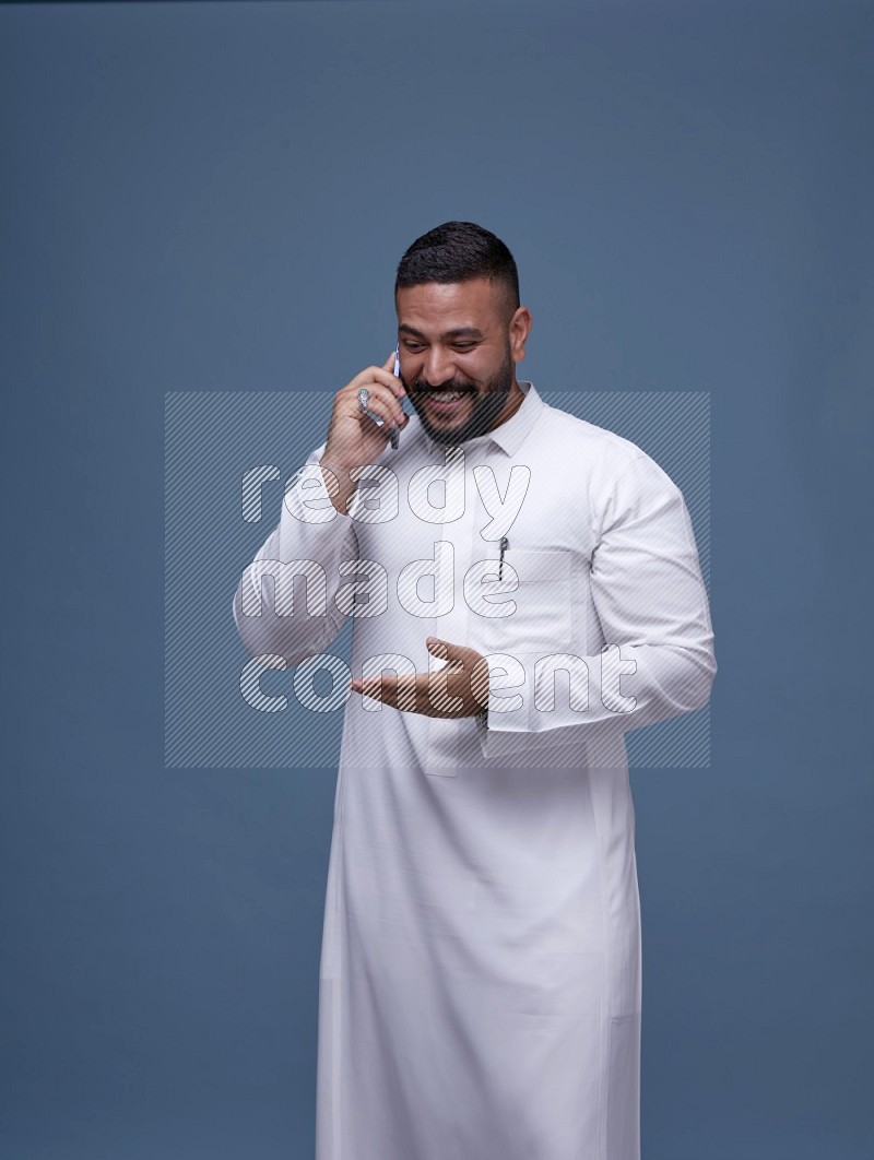 رجل سعودي يرتدي ثوب ابيض ويتحدث في جواله