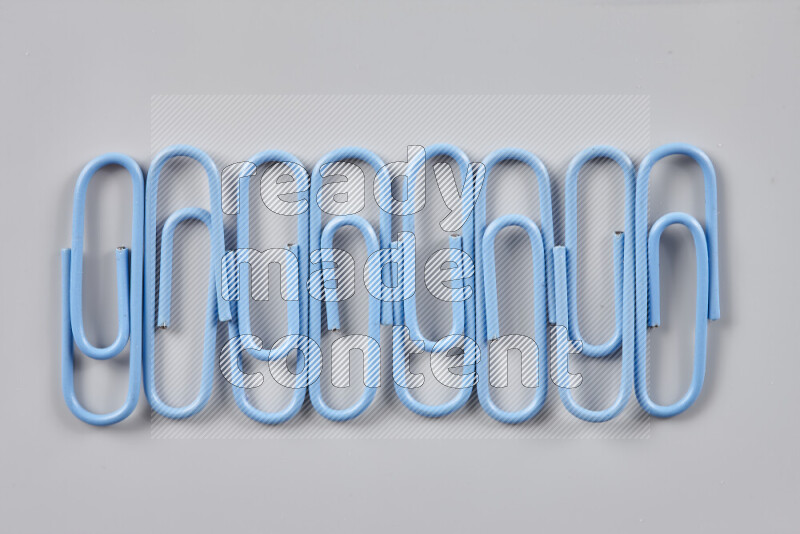 Blue paper clips isolated on a grey background