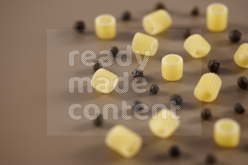 معكرونة مع مكونات متنوعة من الطماطم والثوم والبصل والفلفل الأحمر والفلفل الأسود والفلفل الأبيض وأوراق الغار وإكليل الجبل والهيل على خلفية بيج