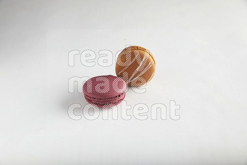 45º Shot of of two assorted Brown Irish Cream, and Red Cherry macarons on white background