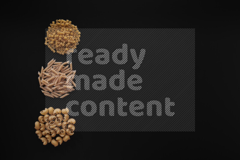 Different pasta types in 3 bunches on black background